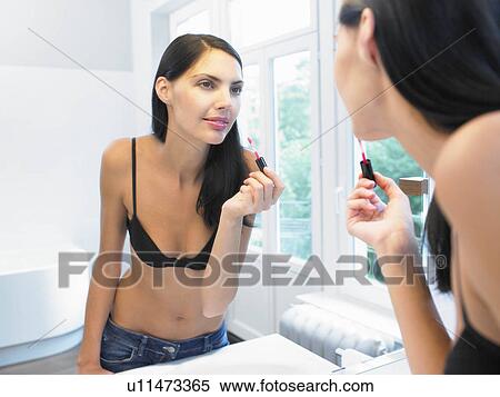 Woman applying makeup, in bathroom View Large Photo Image Stock Photography - Woman applying makeup, in bathroom. Fotosearch