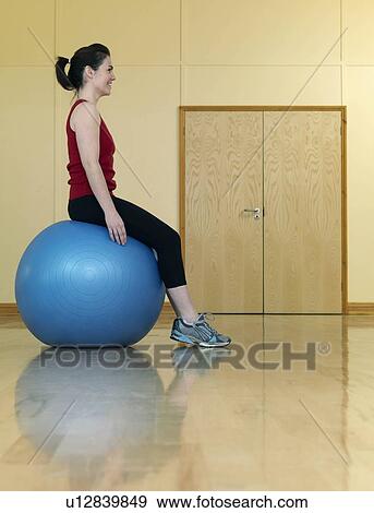 Stock Photo - woman balancing on gym ball. Fotosearch