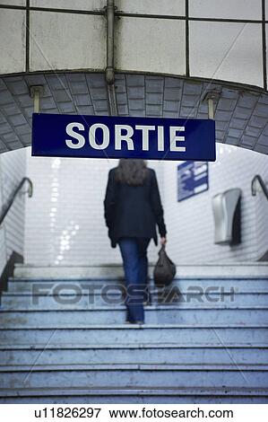 Stock Photo - Woman climbing railway station stairs. Fotosearch