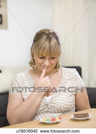 Woman comparing sweets. View Large Photo Image Stock Image - Woman comparing sweets.. Fotosearch