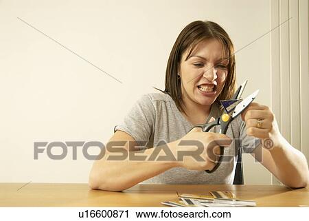 Stock Image - woman cutting credit cards. Fotosearch