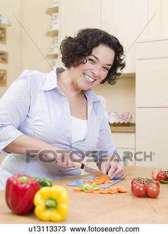 Stock Image - woman cutting vegetables. Fotosearch