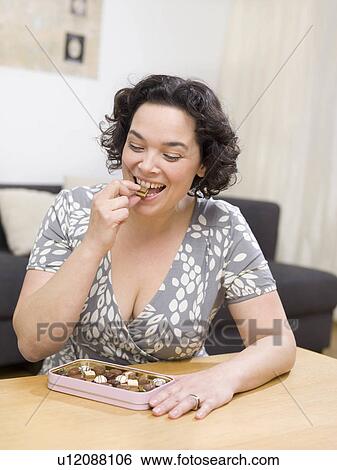 Woman eating chocolate candy View Large Photo Image Stock Photograph - Woman eating chocolate candy. Fotosearch