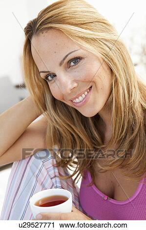 Stock Image - woman having cup of tea. Fotosearch