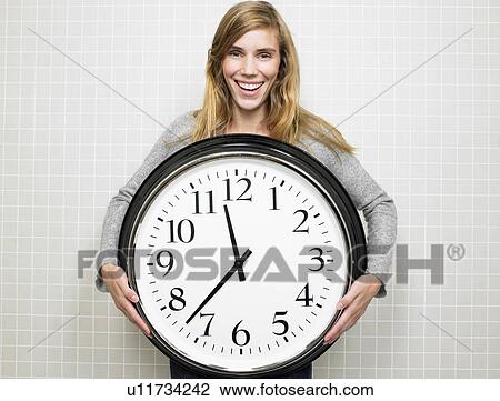Woman holding a big clock View Large Photo Image Stock Image - Woman holding a big clock. Fotosearch
