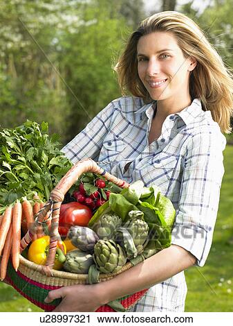 Woman holding a vegetable basket View Large Photo Image Stock Image - Woman holding a vegetable basket. Fotosearch