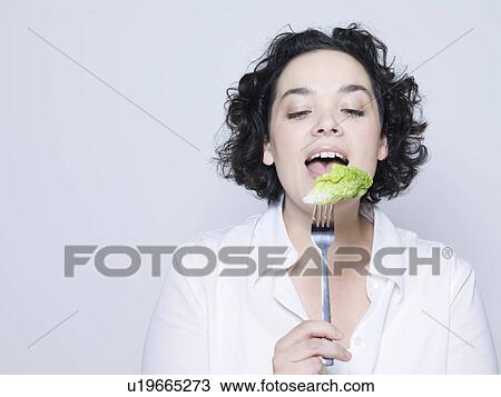 woman holding fork with leaf of salad View Large Photo Image Stock Image - woman holding fork with leaf of salad. Fotosearch