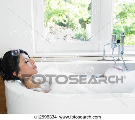 Woman in her bath, flying bubbles View Large Photo Image Picture - Woman in her bath, flying bubbles. Fotosearch