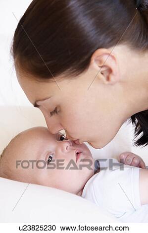 Woman kissing her baby View Large Photo Image Stock Image - Woman kissing her baby. Fotosearch
