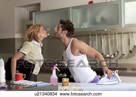 woman kissing partner in kitchen View Large Photo Image Picture - woman kissing partner in kitchen. Fotosearch