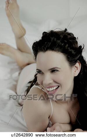 Woman laying on bed, laughing. View Large Photo Image Stock Image - Woman laying on bed, laughing.. Fotosearch