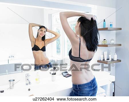 Woman looking at herself in the mirror View Large Photo Image Picture - Woman looking at herself in the mirror. Fotosearch