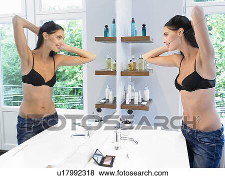 Woman looking at herself in the mirror View Large Photo Image Stock Photo - Woman looking at herself in the mirror. Fotosearch