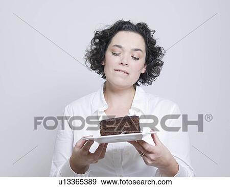 woman looking at plate of cake View Large Photo Image Stock Photo - woman looking at plate of cake. Fotosearch