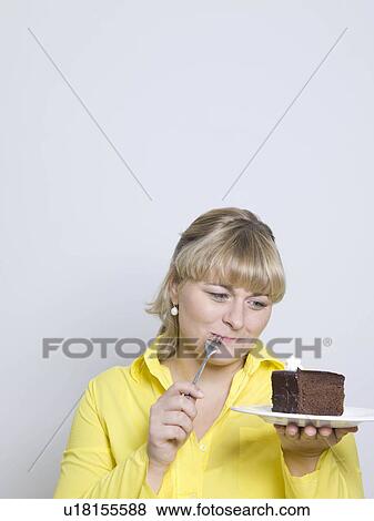 woman looking at plate of cake View Large Photo Image Stock Photo - woman looking at plate of cake. Fotosearch