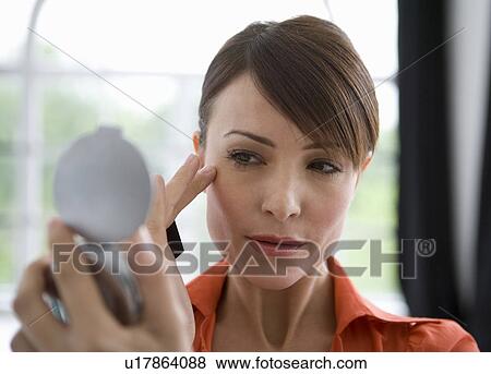 Woman looking at skin in a mirror. View Large Photo Image Stock Photo - Woman looking at skin in a mirror.. Fotosearch