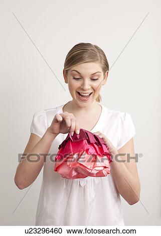 Woman looking into a small bag View Large Photo Image Stock Image - Woman looking into a small bag. Fotosearch