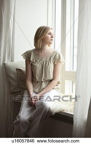 Stock Photograph - Woman looking out of the window. Fotosearch