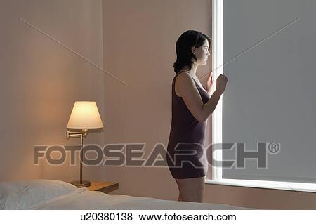 Woman looking out of window View Large Photo Image Stock Photo - Woman looking out of window. Fotosearch
