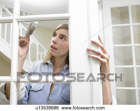 Woman painting the window frame View Large Photo Image Stock Photograph - Woman painting the window frame. Fotosearch