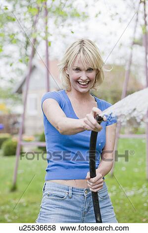 Stock Photo - woman playing with hose. Fotosearch