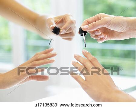 Stock Photo - Woman putting on nail polish. Fotosearch