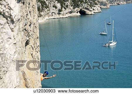 Woman rock climbing, bay in background View Large Photo Image Stock Image - Woman rock climbing, bay in background. Fotosearch