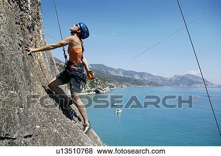 Woman rock climbing, bay in background View Large Photo Image Stock Photo - Woman rock climbing, bay in background. Fotosearch