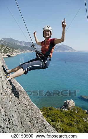 Woman rock climbing looking happy View Large Photo Image Stock Image - Woman rock climbing looking happy. Fotosearch