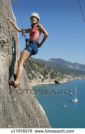 Woman rock climbing looking happy View Large Photo Image Stock Photo - Woman rock climbing looking happy. Fotosearch