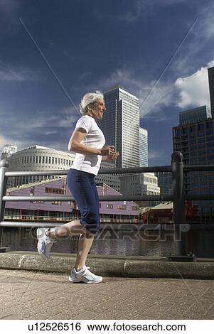 Stock Photograph - woman running by city. Fotosearch