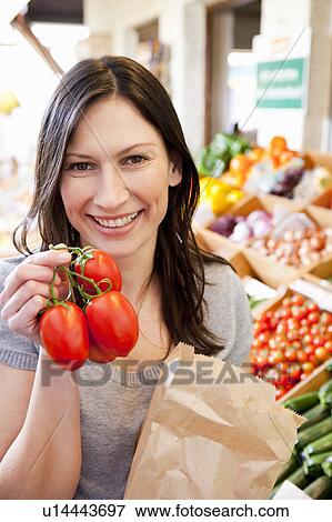 Woman showing fresh tomatoes View Large Photo Image Stock Photo - Woman showing fresh tomatoes. Fotosearch