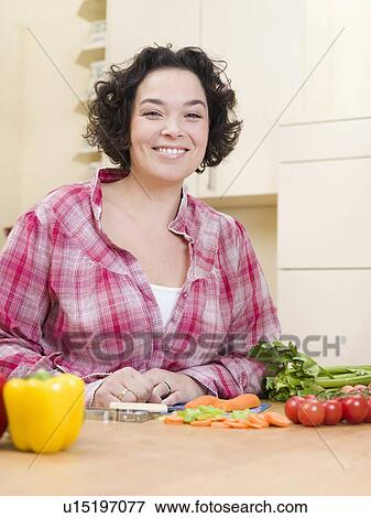Stock Photo - woman sitting in front of vegetables. Fotosearch