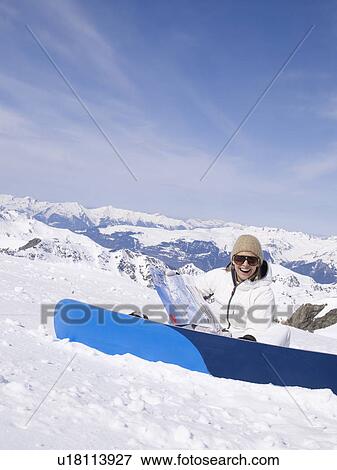 Stock Photo - woman sitting in the snow laughing. Fotosearch