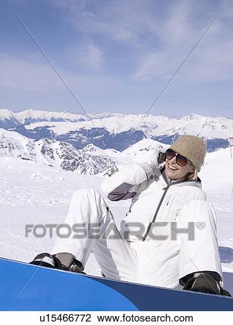 woman sitting in the snow using phone View Large Photo Image Stock Image - woman sitting in the snow using phone. Fotosearch
