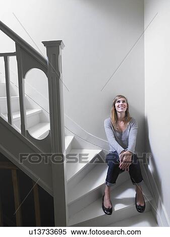 Stock Photography - Woman sitting on stairs. Fotosearch