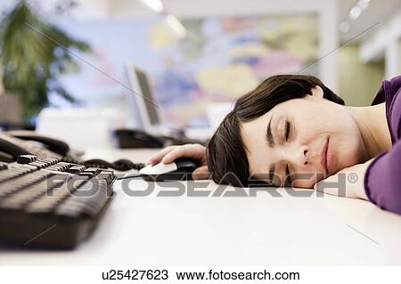 Stock Image - woman sleeping in office. Fotosearch
