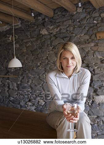 Stock Image - woman smiling at viewer drinking. Fotosearch