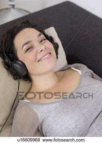 Stock Photo - woman smiling, headphones on.. Fotosearch