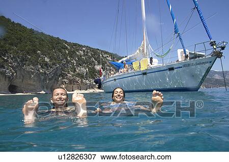 Woman Swimming next to moored boat View Large Photo Image Stock Photo - Woman Swimming next to moored boat. Fotosearch