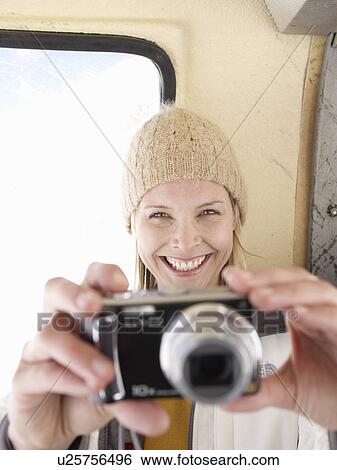 Stock Photograph - woman taking picture smiling. Fotosearch
