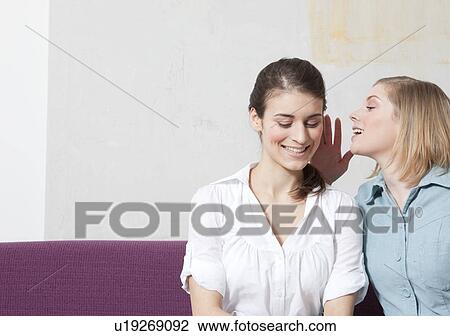 Stock Image - Woman telling a secret. Fotosearch