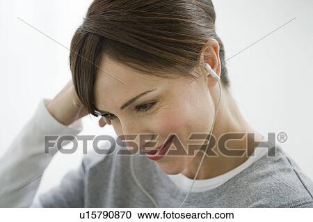 Stock Image - Woman wearing earphones.. Fotosearch