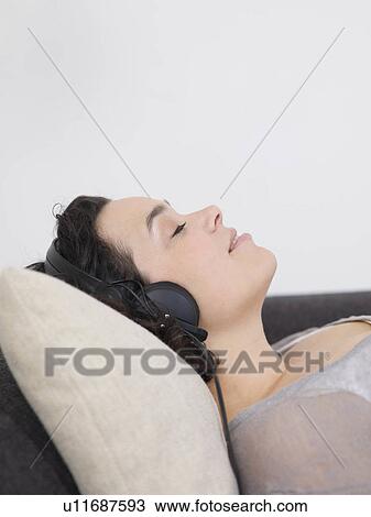 Stock Image - woman with eyes closed, headphones on.. Fotosearch