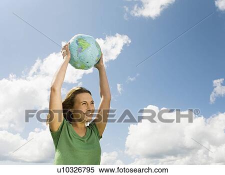 Stock Photography - Woman with Globe Above Head. Fotosearch