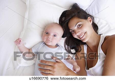 Woman with her baby, in bed View Large Photo Image Stock Photograph - Woman with her baby, in bed. Fotosearch