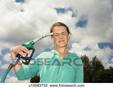 Woman with Pump Nozzle against head View Large Photo Image Stock Image - Woman with Pump Nozzle against head. Fotosearch