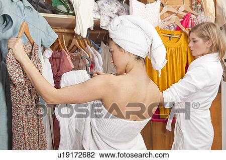Stock Image - Women in bathrobes in front of closet. Fotosearch
