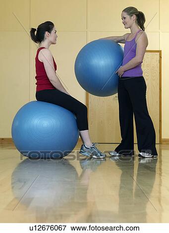 Stock Photo - women relaxing at gym with exercise ball. Fotosearch
