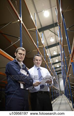 Stock Photo - Worker and manager in warehouse. Fotosearch